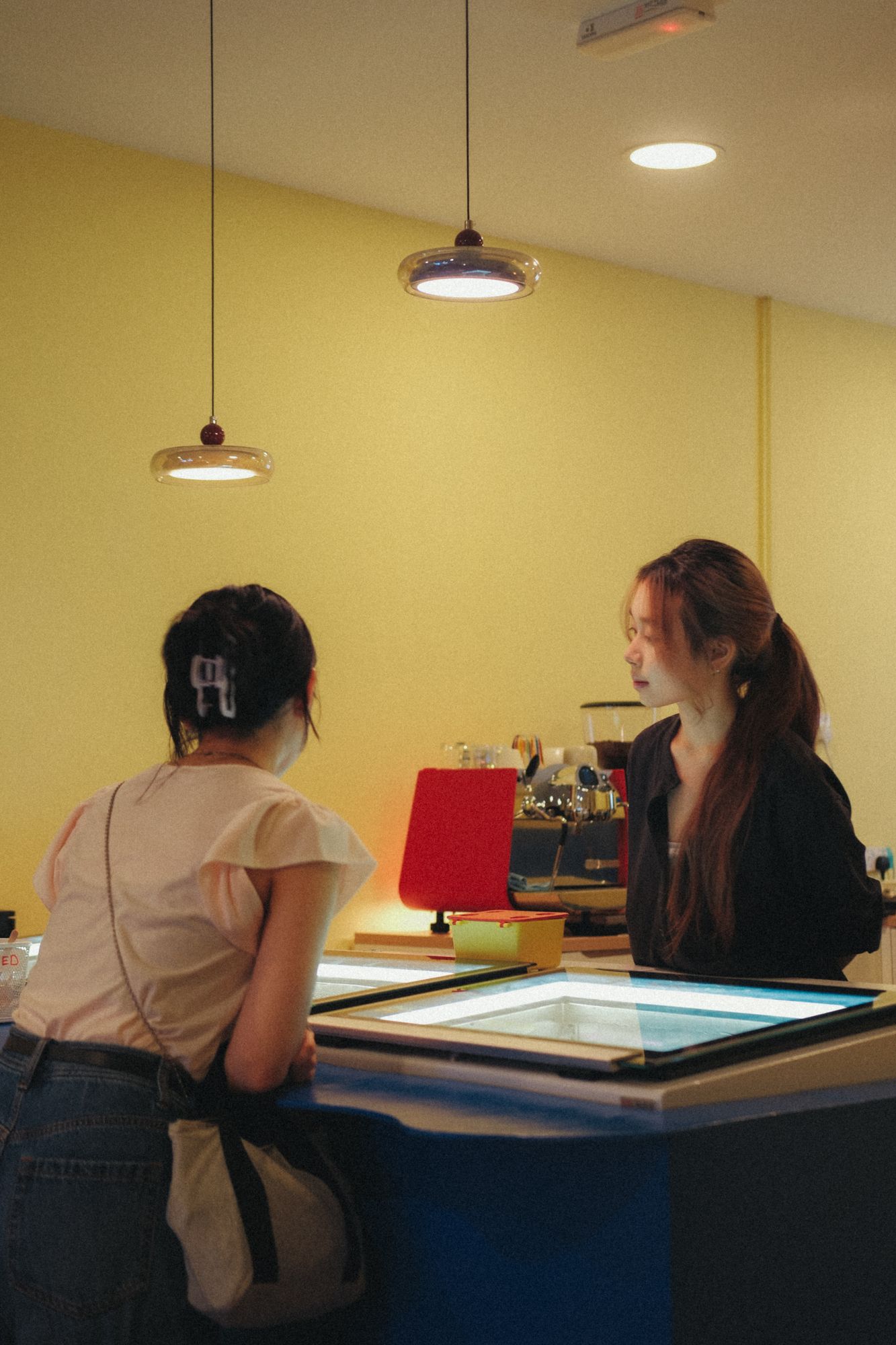 Customers at the Gelulu counter, yellow walls and blue counter